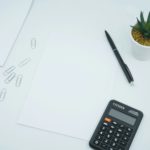 black calculator beside black pen on white printer paper