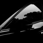 A black and white photo of a car in the dark