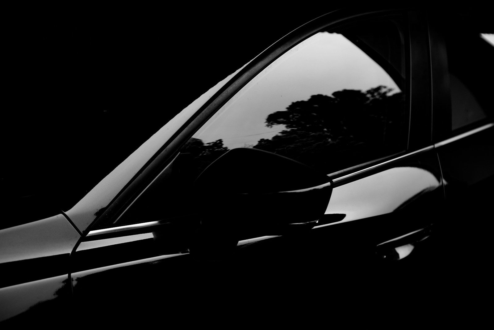 A black and white photo of a car in the dark